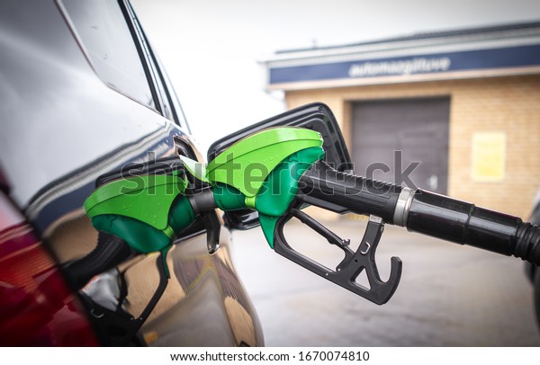 Pumping gas at gas station. Close up\
of fuel monitoring system refueling a petroleum to vehicle at gas\
station. Fuel nozzle to refill fuel in car at gas station.\
