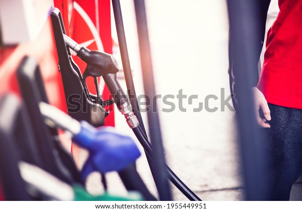 Pumping gas at gas station. Close\
up of a hand holding fuel nozzle.Colorful Petrol pump filling\
nozzles isolated on white background , Gas station in a\
service.