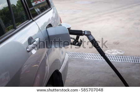 Pumping gasoline fuel in car at gas station - servo.