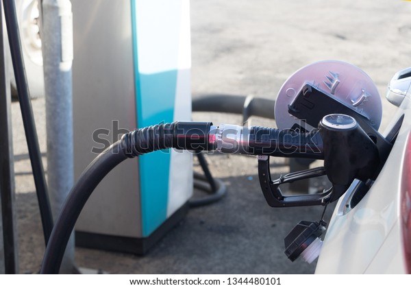 pumping petrol at gas station into vehicle.hand\
using a fuel nozzle at a gas station.Petrol Gasoline in Cold\
weather Safe drive\
concept.