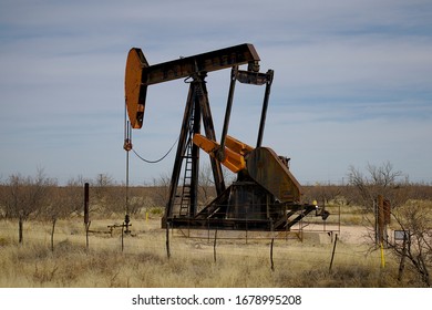 Pumping Unit In The Permian Basin - A Black And Red Pumping Unit Is Seen By The Side Of The Highway In The West Texas Oil Field.