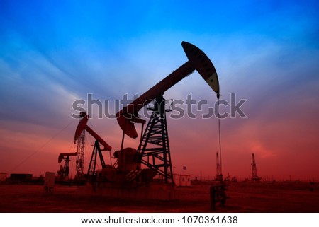 Pumping unit in the work, under the background of the setting sun 