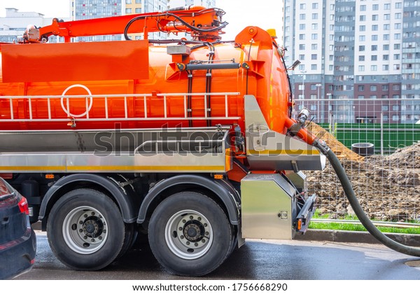 Pumping water from\
sewage canals during the construction of roads in the city. Truck\
with orange water tank