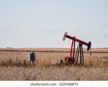 Pumpjack for extraction of crude oil near a corn field on an October morning in rural southeastern Illinois, USA. Foreground focus. For themes of energy, resources, and the environment. - Powered by Shutterstock