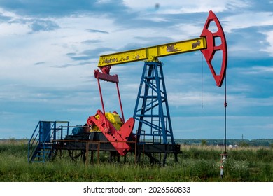 Pumpjack Piston Pump Operating At An Oil Well In Field Outdoors