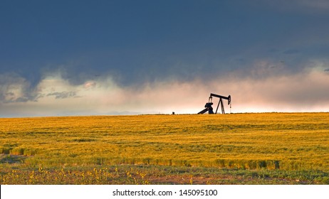 A pumpjack silhoutte with dramatic sunset.