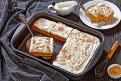 Pumpkin Cake With Cream Frosting In Baking Pan And One Slice On A White Plate, Horizontal View From Above