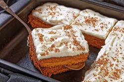 Pumpkin Cake With Cream Frosting In Baking Pan And One Slice On A Cake Shovel, Horizontal View From Above, Close-up
