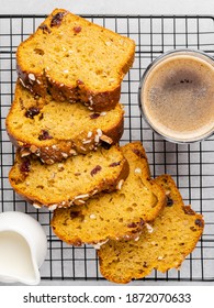 Pumpkin Cake With Dried Cranberry, Almond Nuts And Orange Zest With Glass Of Coffee And Cream Jug On Cooling Rack.  Tasty Homemade Dessert. Sliced Loaf Of Autumn Pound Cake. Top View Cake