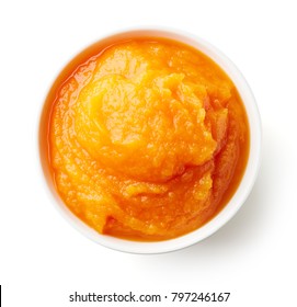 Pumpkin and carrot baby puree in round dish isolated on white background, top view