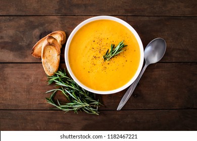 Pumpkin and carrot  Cream soup on  wood rustic  background. Autumn cream-soup in country style. Top view. Copy space