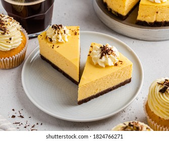 Pumpkin cheesecake with chocolate base layer and cream frosting. Autumn squash dessert. Piece of orange and brown cheesecake with chocolate sprinkles and a cup of coffee. Close up view. Fall sweets. - Powered by Shutterstock