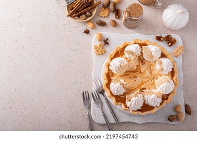 Pumpkin Cheesecake Swirl Pie Topped With Whipped Cream On A Marble Board, Original Thanksgiving Dessert Idea, Overhead With Copy Space