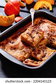 Pumpkin Chocolate Chips Sheet Cake Cut In Slices In A Baking Dish On Dark Concrete Table, Vertical View From Above, Close-up