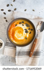 Pumpkin Cream Soup. Pumpkin And Carrot Puree Soup With Turmeric, Cream, Paprica, Chives And Pumpkin Seeds On Grey Background. Vegetarian Cousine. Vegan Recipe. Green Living. Organic Food. Food Styling