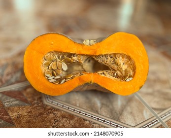 A pumpkin is a cultivar of winter squash that is round with slightly ribbed skin, and is most often deep yellow to orange in coloration. Pumpkin seeds are edible, flat, oval-shaped seeds - Shutterstock ID 2148070905