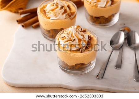 Pumpkin dessert in a cup, pudding or no bake cheesecake with spices, caramel sauce and whipped cream