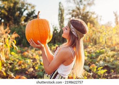 Pumpkin harvest. Young woman farmer picking autumn crop of pumpkins on farm. Agriculture. Thanksgiving and Halloween preparation. Fall vibe