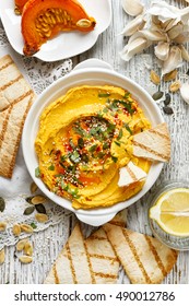 Pumpkin hummus, creamy and delicious dip on a white plate, top view
