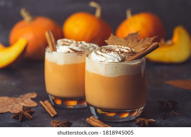 Pumpkin Latte Drink. Autumn Coffee With Spicy Pumpkin Flavor And Cream On A Dark Background. Seasonal Fall Drinks For Halloween And Thanksgiving