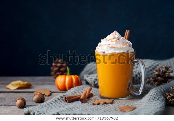 Pumpkin latte with spices.\
Boozy cocktail with whipped cream on top on a wooden background.\
Copy space.