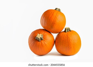 Pumpkin on a white background. Isolated halloween pumpkin isolate on white to insert into your project or design. Three orange pumpkins stacked in a pile cast a shadow