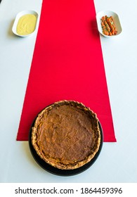 Pumpkin Pie, Mashed Potatoes And Glazed Carrots On A White Tablecloth And Red Table Runner, Top View