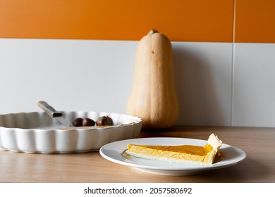 Pumpkin Pie Slice And Butternut Squash In Table With Orange Wall