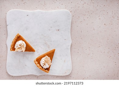 Pumpkin Pie Slices Topped With Whipped Cream On A Marble Board, Minimalistic Look Overhead View With Copy Space