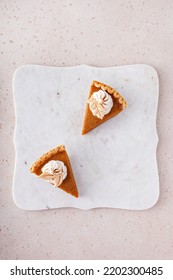 Pumpkin Pie Slices Topped With Whipped Cream On A Marble Board, Minimalistic Look Overhead View With Copy Space