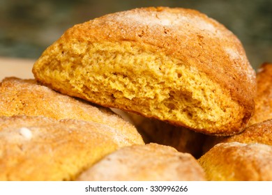 A Pumpkin Scone Sitting Atop An Arrangement Of Similar Scones.