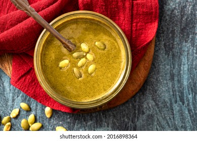 Pumpkin Seed Butter In A Glass Jar Close-up. Pumpkin Seed Paste. Vegan Food, Spread And Topping.