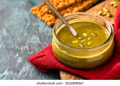 Pumpkin Seed Butter In A Glass Jar Close-up. Pumpkin Seed Paste. Vegan Food, Spread And Topping.