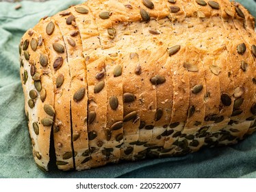 pumpkin seeds encrusted on baked seeded sliced bread loaf - Shutterstock ID 2205220077