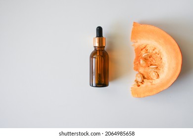 Pumpkin Seeds Oil Bottle, Pumpkins. Selective Focus. Creative Flat Lay Of Glass Bottle With Organic Natural Pumpkin Seed Oil Extract Cosmetics For Skin And Hair Care.Minimal Beauty Spa Treatment 