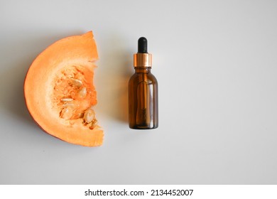 Pumpkin Seeds Oil Bottle, Pumpkins. Selective Focus. Creative Flat Lay Of Glass Bottle With Organic Natural Pumpkin Seed Oil Extract Cosmetics For Skin And Hair Care.Minimal Beauty Spa Treatment 