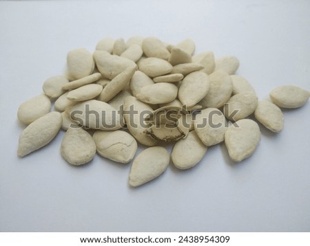 Pumpkin seeds in shell and roasted, creamy white salted,  Pealed Pumpkin seed is visible. Beneficial for health and full of nutrition. 