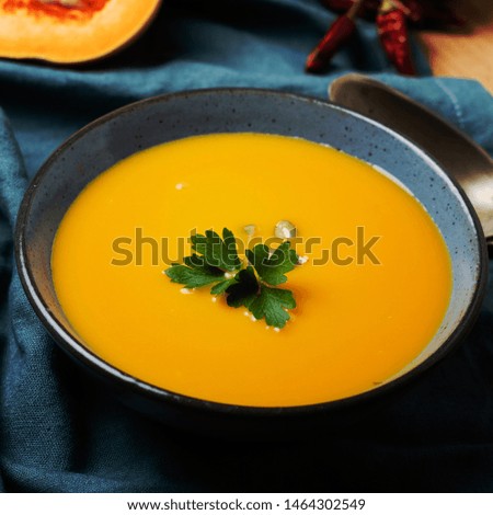 Pumpkin soup in blue ceramic bowl.