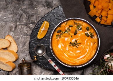 Pumpkin Soup In A Bowl On A Rustic Setup With Food Ingredients