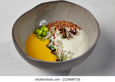 Pumpkin Soup With Crab In Handmade Ceramic Bowl. Innovative Recipes - Cream Soup With Crab And Cheese Espuma On White Concrete Background. Modern Food In Dishware