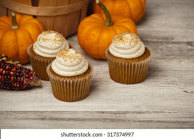 Pumpkin Spice Cupcakes And Mini Pumpkins In Fall Scene. 