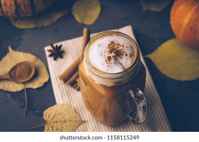 Pumpkin Spice Latte Or Coffee With Cinnamon. Autumn, Fall Or Winter Hot Drink. Background With Yellow Leaves