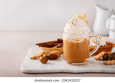 Pumpkin spice latte in a mug topped with whipped cream and cinnamon - Powered by Shutterstock