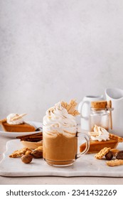 Pumpkin spice latte in a mug topped with whipped cream and cinnamon - Shutterstock ID 2341432269