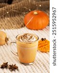 Pumpkin spice latte with whipped cream and ingredients.