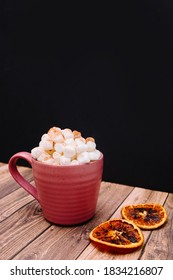 Pumpkin Spice Latter With Marshmallows And Cinnamon On Wooden And Black Background. Orange Spice Nearby. Food Background. Coffee Drink. Pink Mug. 