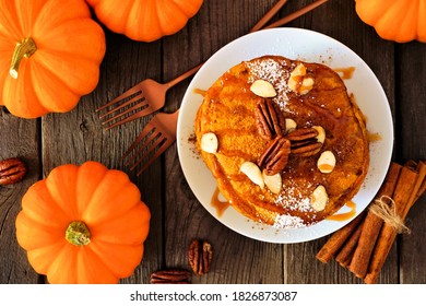 Pumpkin Spice Pancakes With Caramel Sauce And Nuts. Top View Table Scene On A Dark Wood Background. Fall Breakfast Concept.