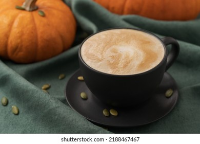 Pumpkin spicy latte in black cup on linne cloth, shallow focus - Shutterstock ID 2188467467