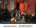 Pumpkins, fall foilage, candles, dog skeletons cover the stairs outside a Upper East Side townhouse in New York, N.Y., Monday, Oct. 28, 2024. (Photo: Gordon Donovan)