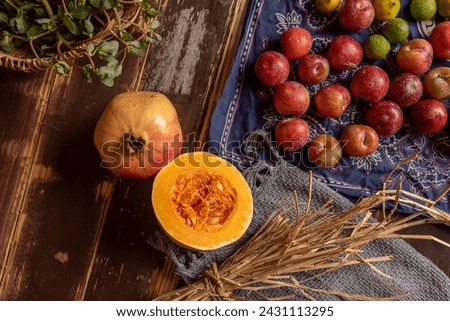 Pumpkins and many other colors and varieties of fruits and vegetables are on the wood grain table